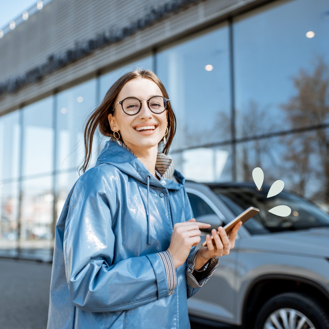 Woman holding a phone at a car dealership