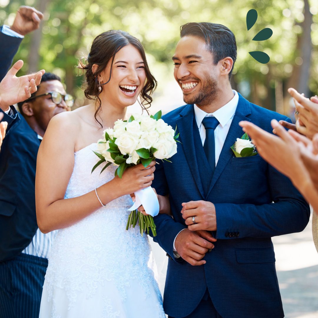 Young couple in wedding attire walking down the aisle