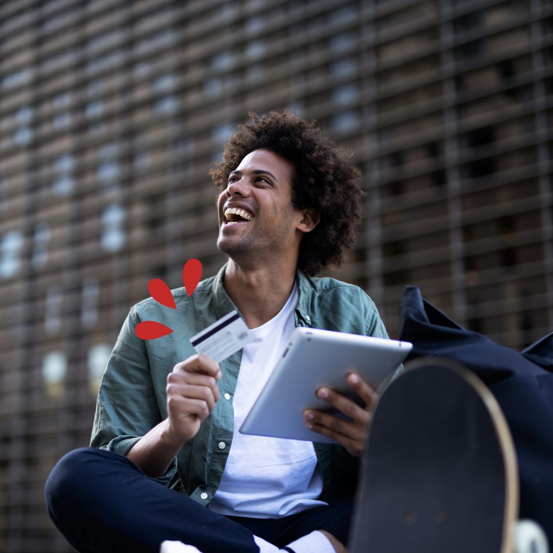 VISA Credit Cards Young man sitting on the ground with a tablet and credit card