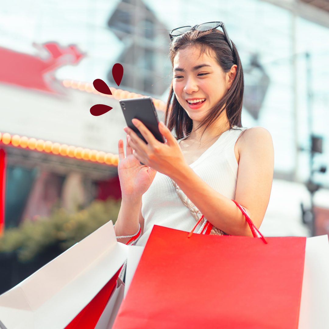 Visa Platinum Cash Rewards Young woman tapping on her phone with shopping bags