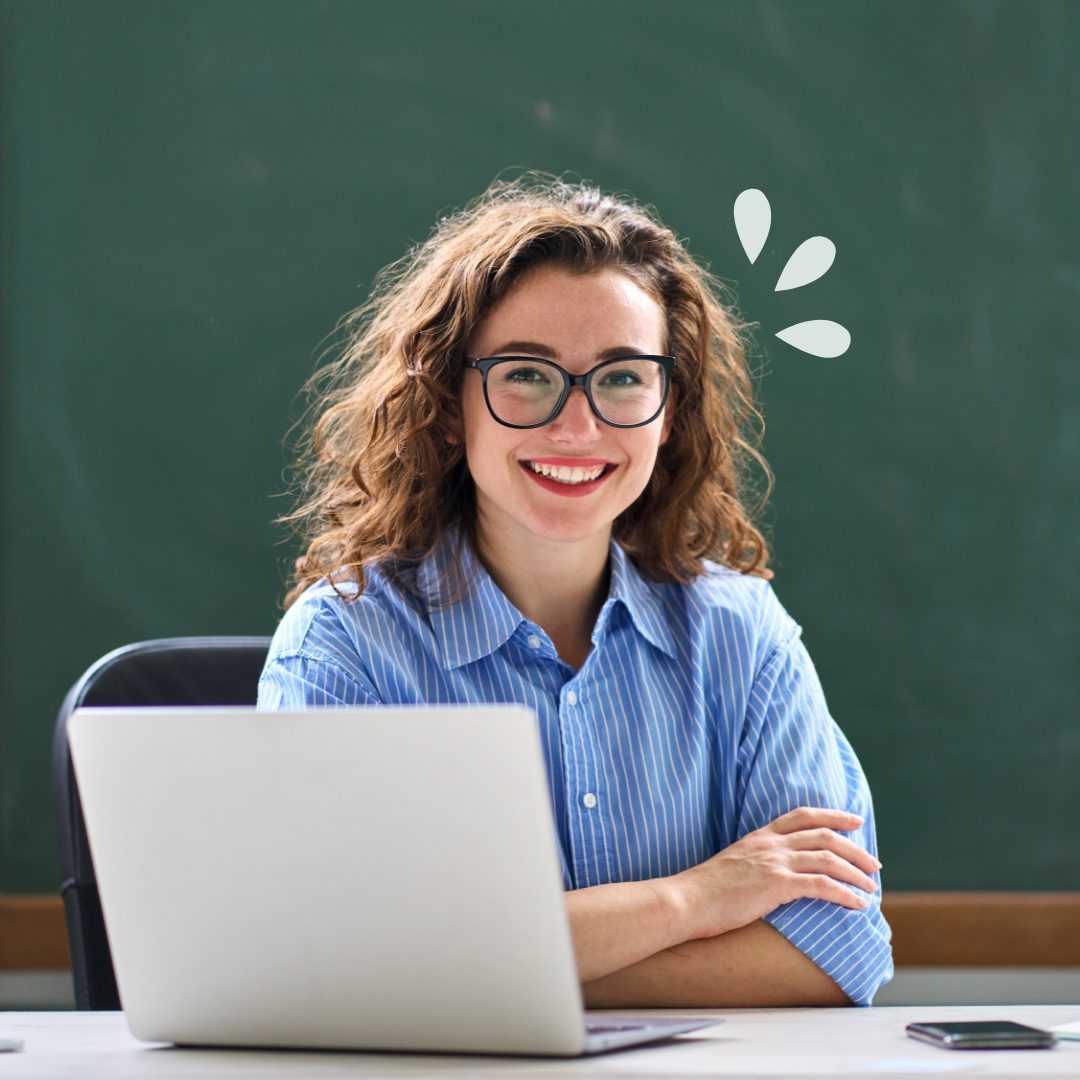 Why Work With Us Teacher sitting at her desk