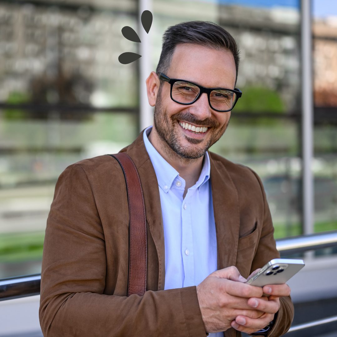 Man smiling front on with a phone in his hands