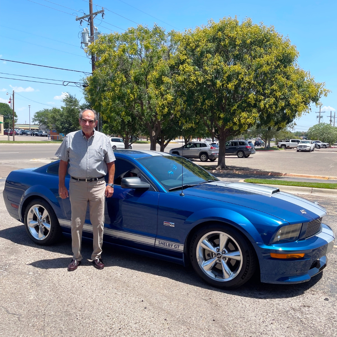 Mr. Jerry with Ford Mustang Mr. Jerry standing next to his blue Ford Mustang